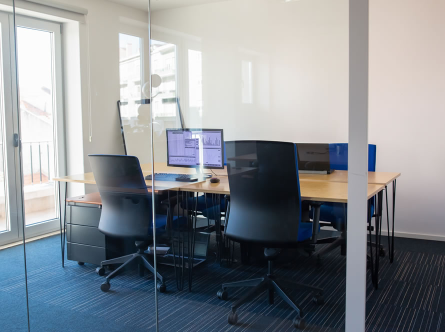 Despacho luminoso para reuniones con mobiliario de oficina y equipos informáticos.